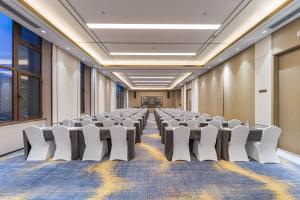 a conference room with rows of chairs and a screen at Madison Hotel, Qingdao Laoshan Polar Ocean Park in Qingdao