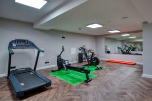 a gym with treadmills and exercise equipment in a room at Sunday Hotel Bonn in Bonn