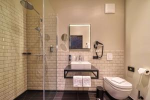 a bathroom with a shower and a sink and a toilet at Sunday Hotel Bonn in Bonn +82 photos