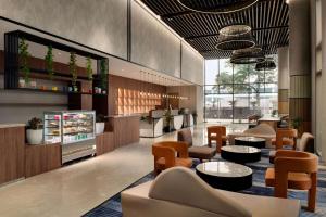 a restaurant with tables and chairs in a lobby at Ramada Encore By Wyndham Bhiwadi Phool Bagh Chowk in Bhiwadi