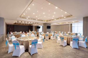 a banquet hall with tables and chairs in a room at Ramada Encore by Wyndham Jingzhou Shashi in Jingzhou