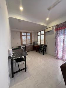 a living room with a table and chairs and a kitchen at EasyStay Apartment Langkawi in Kuah +12 photos