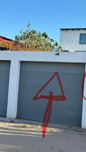 a garage door with a red arrow painted on it at Escape de altura in San Luis Río Colorado