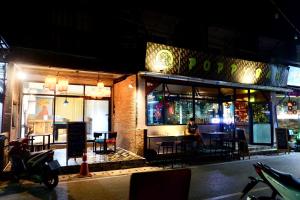 Un uomo seduto al ristorante di notte di Poppy hostel a Pai