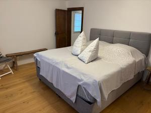 une chambre avec un lit avec des draps blancs et des oreillers dans l'établissement Fass ohne Boden Haus Levi, à Mechernich