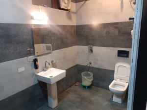 a bathroom with a sink and a toilet at Hotel Kuber in Rāi +29 photos