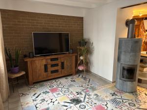 un salon avec une télévision et une cheminée dans l'établissement Fass ohne Boden Haus Levi, à Mechernich