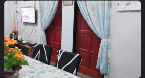 two pictures of a room with a table and a door at Inap Desa Jalan Baru in Kampong Sedim Number Two