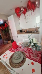a table with two plates and roses on it with hearts at La Love - Love room Marseille in Marseille