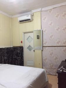 Zimmer mit einem Bett und einer Tür mit Zeichnungen an der Wand in der Unterkunft Surya Wijaya Homestay in Timuran