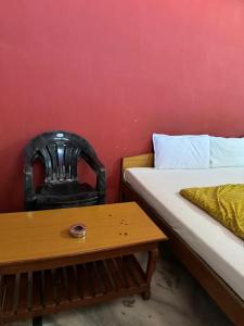斋浦尔Krishna Guest House的一间卧室，里面有一张床、一把椅子和一张桌子