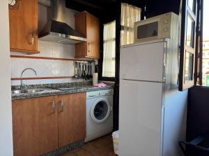 a kitchen with a white refrigerator and a washing machine at Apartamento Corredera in Córdoba +12 photos