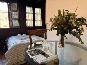 a room with a table with a vase of flowers at Apartamento Corredera in Córdoba
