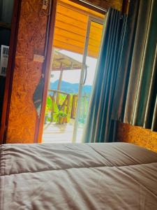 a bedroom with a bed and a sliding glass door at Rakkhao Inthanon homestay LoveInthanon in Ban Yang Di Pha Mop