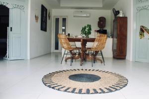 a dining room table with chairs and a rug on the floor at Dwipa Peaceful, spacious 2 bedroom villa in Sanur