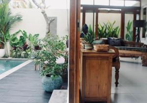 a living room with plants and a pool at Dwipa Peaceful, spacious 2 bedroom villa in Sanur