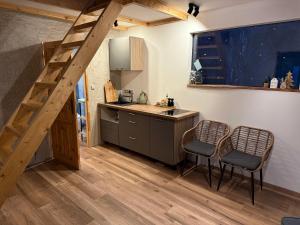 una cucina con scala e 2 sedie in una stanza di Kousek klidu pod skálou a Chrastava