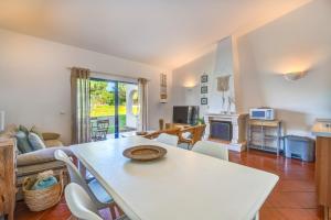 a living room with a table and a couch at PARAISO DE ALVOR - A true paradise in an amazing nature place with direct access to the pool - Peace and relax - next to Alvor Village and the beach in Alvor