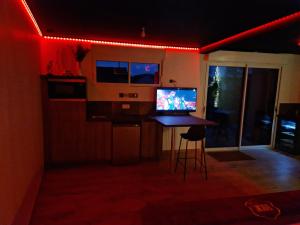 a room with a table with a television on it at Escapade Romantique à Saint Omer-Espace Totalement Privatisé Avec Terrasse in Saint-Omer