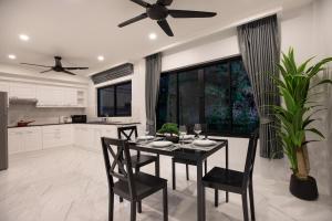 cocina con mesa y sillas y ventilador de techo en Baan Chom View Residences, en Kamala Beach