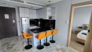 a kitchen with a black counter and orange bar stools at Emerald Terrace Resort 2 bedrooms Panoramic Ocean View Top Floor in Patong Beach