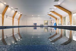 an indoor swimming pool with a swimming floor and windows at Bosmuis Ardennen, Genieten in de bossen in chalet 226 in Durbuy