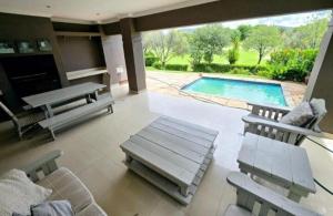 a large living room with a pool and chairs at Pecanwood Estate Dream views 4 bedroom Villa with pool in Hartbeespoort