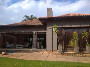 a house with a patio with plants in the yard at Pecanwood Estate Dream views 4 bedroom Villa with pool in Hartbeespoort