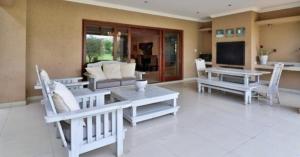 a living room with white chairs and tables and a couch at Pecanwood Estate Dream views 4 bedroom Villa with pool in Hartbeespoort