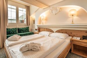 2 letti in camera d'albergo con asciugamani di Hotel Berghof Mayrhofen GmbH a Mayrhofen