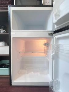 un réfrigérateur vide avec sa porte ouverte dans une cuisine dans l'établissement Ueno Sakura House, à Tokyo 38 autres photos