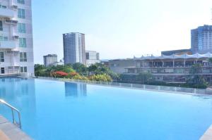 a large swimming pool with a city in the background at Davao Central Suites in Davao City +4 photos