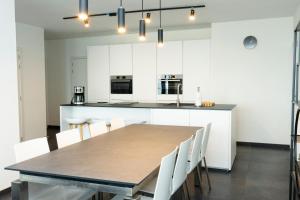 a kitchen with a table and white cabinets at Zeedijk 237 Middelkerke in Middelkerke