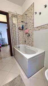 Una bañera blanca en un baño con ducha. en Casa Linabelli Reggio Emilia, en Reggio Emilia