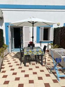 a table and chairs with an umbrella on a patio at Ponzamania IL Pescatore in Ponza