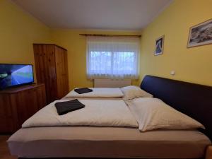 A bed or beds in a room at Ilona Apartmanház