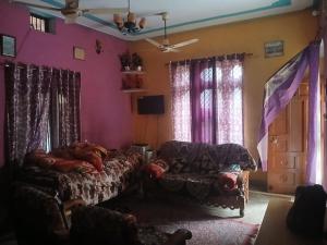 a living room with a couch and pink walls at CIRCLE GOLDEN HOUR iNDiA in Roorkee
