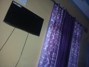 a television and purple curtains in a room at CIRCLE GOLDEN HOUR iNDiA in Roorkee