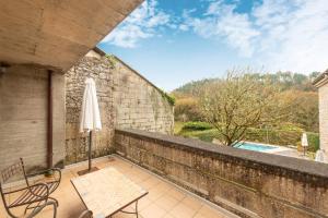 a patio with a table and an umbrella and a pool at Casa Doña Blanca, Ourense in San Clodio