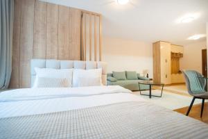 a bedroom with a large white bed and a couch at Pirin Sense Charm Studio SPA - FREE Parking in Bansko