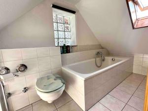 a bathroom with a toilet and a bath tub at Appartement direkt am Schwarzwald in Bühl +8 photos