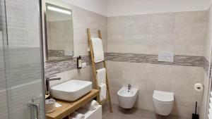 a bathroom with a sink and a toilet and a mirror at Casa Faét in Adro +4 photos