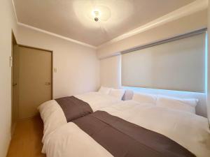 Ένα ή περισσότερα κρεβάτια σε δωμάτιο στο Residence Yu - Spacious 2BR Apartment Central Yet Peaceful Stay