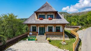 a small house with a roof on the side of a road at Căsuța din Deal in Moisei