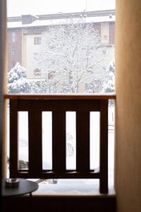 una finestra con vista su un albero innevato di Pirin Sense Studio - SPA - FREE Parking a Bansko