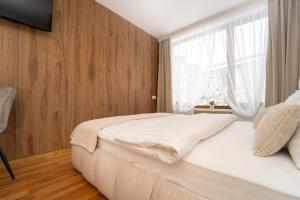 una camera da letto con un letto bianco e una finestra di Pirin Sense Studio - SPA - FREE Parking a Bansko