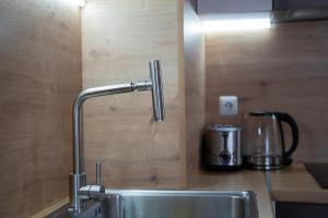 a kitchen sink with a faucet next to a coffee maker at Pirin Sense Deluxe Studio - SPA - FREE Parking in Bansko