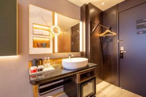 天津市にあるCitiGO Hotel Tianjin Binjiang Roadの洗面台と鏡のあるバスルーム