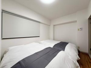 Un dormitorio con una gran cama blanca y una gran ventana. en Residence Yu by b hotel - Relaxing 2BR Near City Center Dining & Kitchen, en Hiroshima