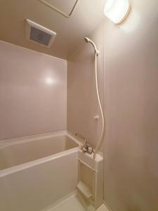 un baño con bañera y ducha en Residence Yu by b hotel - Relaxing 2BR Near City Center Dining & Kitchen, en Hiroshima